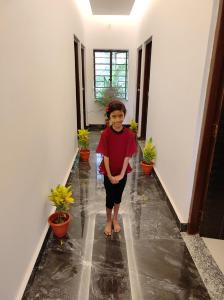 une femme debout dans un couloir avec des plantes en pot dans l'établissement Anand Vihar, à Jamshedpur
