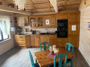 eine Küche mit einem Holztisch mit Stühlen und einem Tisch und einem Tischgestell in der Unterkunft Milleri in Salacgrīva