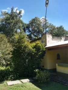 ein Haus mit Bäumen und einem Straßenlicht darüber in der Unterkunft Quinta - Casa de Campo in Merlo