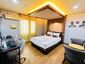 1 dormitorio con 1 cama y escritorio con ordenador en Sweet Hotel, en Jeju