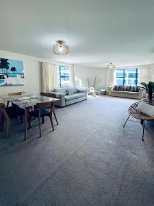 a living room with a table and a couch at Oceanside Apartment in Mount Maunganui