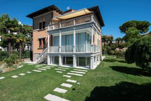 a large house with a lawn in front of it at Ca' delle Contesse - Villa on lagoon with private dock and spectacular view in Venice-Lido