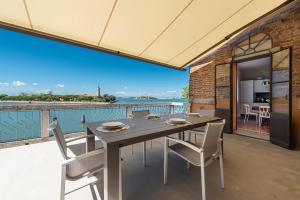 a dining room with a table and chairs on a balcony at Ca' delle Contesse - Villa on lagoon with private dock and spectacular view in Venice-Lido