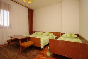 Cette chambre d'hôtel comprend 2 lits, une table et une table. dans l'établissement Apartments with a parking space Umag - 2539, à Umag