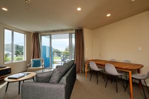 ein Wohnzimmer mit einem Sofa und einem Tisch in der Unterkunft Kaikoura Luxury Apartments - Formerly Waves Luxury Apartments in Kaikoura
