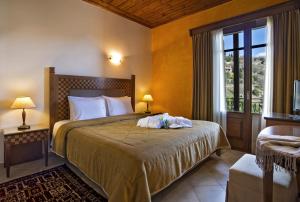 a bedroom with a bed with two towels on it at Alpen House Hotel & Suites in Arachova