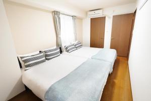 een slaapkamer met 2 bedden en een raam bij Dio Higashi Shinsaibashi in Osaka