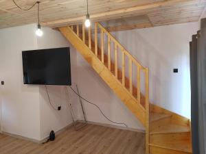 a living room with a staircase and a flat screen tv at Domek u Antosia in Mechelinki