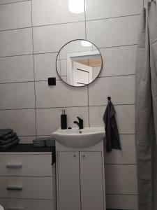 a bathroom with a sink and a mirror at Domek u Antosia in Mechelinki