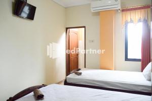 A bed or beds in a room at PKPN Syariah Boyolali Mitra RedDoorz