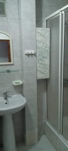 ein weißes Bad mit einem Waschbecken und einer Dusche in der Unterkunft Квартира проспект Церетели in Tbilisi City