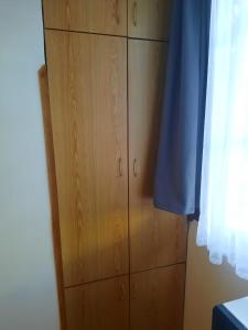 einen Holzschrank in einem Zimmer mit Fenster in der Unterkunft Квартира проспект Церетели in Tbilisi City