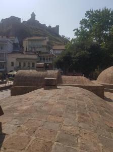 un banco de piedra sentado en la parte superior de una acera de ladrillo en Old Town-Booking Apartment, en Tiflis