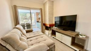 Una televisión o centro de entretenimiento en UM OÁSIS EM CAMPOS - Lindo e Novo Ap - Próx a Capivari e ao lado da Fonte Simão - com Varanda Gourmet, Lareira & Calefação - UNIDADE COM VISTA PRIVILEGIADA PARA A FONTE