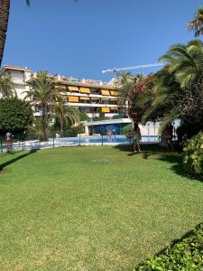 un grand parc avec des palmiers et un bâtiment dans l'établissement Golden Mile Apartment, à Marbella