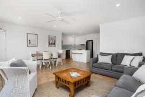 a living room with a couch and a table at Summer Salt in Byron Bay