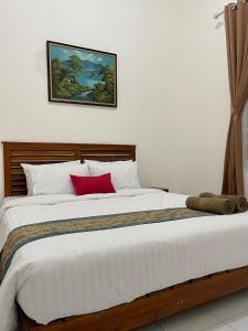 a bedroom with a large white bed with red pillows at AW City House Yogyakarta in Yogyakarta