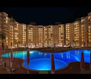 - un grand bâtiment avec une grande piscine la nuit dans l'établissement اكوا فيو الساحل الشمالى - مصريين فقط, à El Alamein