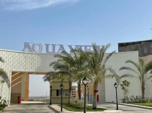 a building with palm trees in front of it at اكوا فيو الساحل الشمالى - مصريين فقط in El Alamein