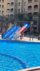 a slide in a swimming pool next to a swimming pool at اكوا فيو الساحل الشمالى - مصريين فقط in El Alamein