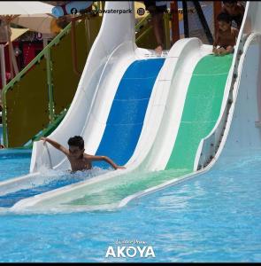 un joven deslizándose por un tobogán de agua en una piscina en اكوا فيو الساحل الشمالى - مصريين فقط, en El Alamein