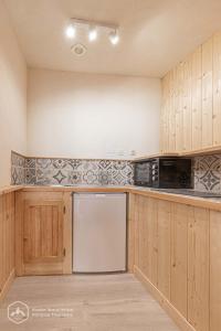 a kitchen with wooden cabinets and a dishwasher at LA CAZETTA in Bonneval-sur-Arc