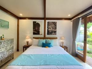 a bedroom with a large bed with blue pillows at The Palms Canggu in Canggu