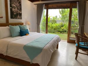 a bedroom with a large bed and a large window at The Palms Canggu in Canggu