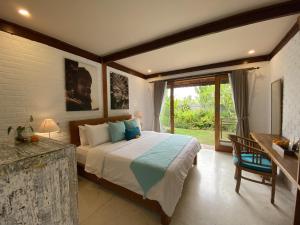 a bedroom with a bed and a large window at The Palms Canggu in Canggu