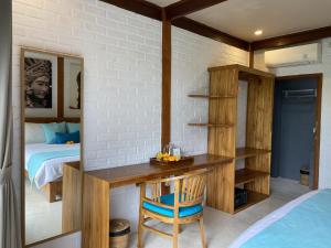 a bedroom with a desk and a bed and a bed at The Palms Canggu in Canggu