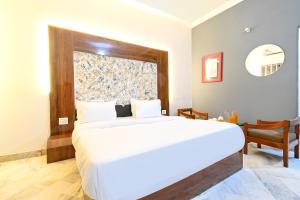 a bedroom with a large white bed and a window at FabHotel Classic Holiday in Jaipur