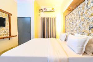 a bedroom with a large white bed and a window at FabHotel Classic Holiday in Jaipur