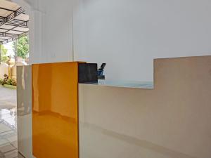 a kitchen with a yellow and white counter top at OYO 91599 Penginapan Mutiara Madiun in Madiun