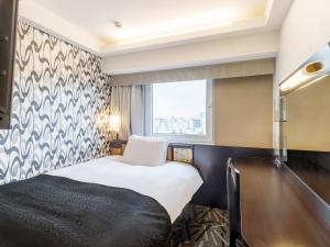 une chambre d'hôtel avec un lit et une fenêtre dans l'établissement APA Hotel Asakusa Kuramae Ekimae, à Tokyo