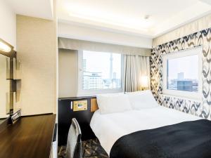 東京にあるアパホテル〈浅草 蔵前駅前〉のベッドと窓が備わるホテルルーム