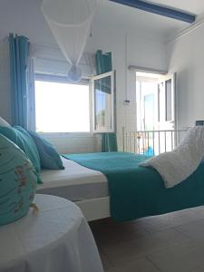a bedroom with two beds and a window at Παραθαλάσσιο Σπίτι θαλάσσια Αυρα in Nafplio