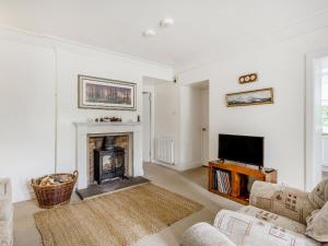 a living room with a fireplace and a tv at Ralston Bothy in Blairgowrie