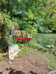 une table de pique-nique et un banc dans un parc dans l'établissement Jacuzzi avec vue sur la rivière l'Yerres, à Yerres