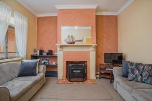 a living room with a couch and a fireplace at Albany Historic Cottage in Albany