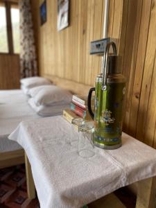 a table with two glasses and a thermos on it at Chimney Farmstay in Kurseong