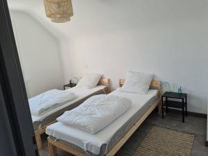 duas camas individuais num quarto com duas mesas em Le Clos de Kergavat 3 étoiles em Plouharnel