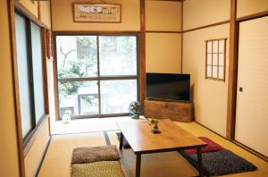 a living room with a table and a tv at Kagurazaka Retro BAR & HOTEL in Tokyo +20 photos