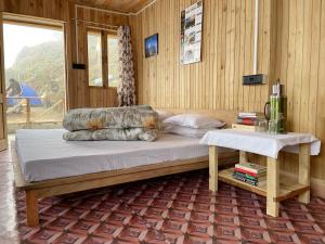 a bedroom with a large bed and a table at Chimney Farmstay in Kurseong