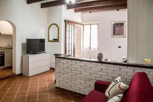 a living room with a couch and a counter with a tv at Casa Vacanze da Angela in Alghero