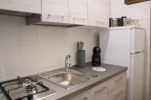 a kitchen counter with a sink and a refrigerator at Casa Vacanze da Angela in Alghero +24 photos