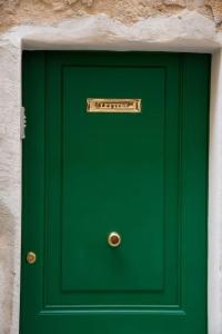 a green door with a sign on top of it at Casa Vacanze da Angela in Alghero