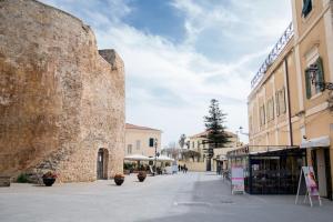 a street in front of a large stone building at Casa Vacanze da Angela in Alghero