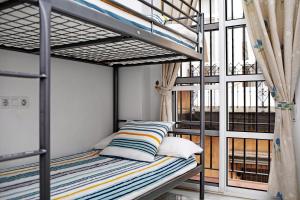 a bunk bed in a room with a window at Casa Milagros in Sanlúcar de Barrameda