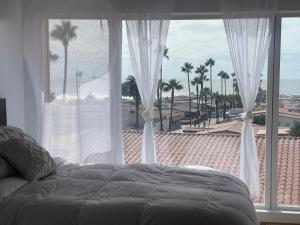 a bedroom with a bed and a view of the ocean at Beachfront Bungalow Rosarito Beach in Rosarito