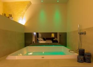 bañera en una habitación con dormitorio en Iris Luxury Suite, en Altamura